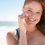 red-head-woman-at-the-beach-applying-sunscreen-to-her-face.jpg